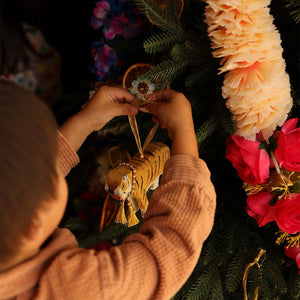 tinsel tiger ornament for xmas by doing goods held by child to hang on xmas tree