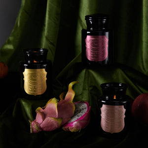 apothecary noir scented candle collection style with green fabric background and dragonfruit 