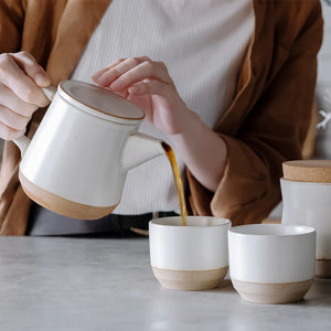 tea poured out of ceramic teapot into a cup