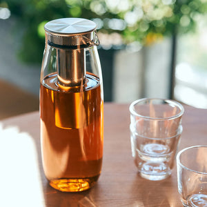 cold brew jar in glass and stainless steel by kinto on table with glasses