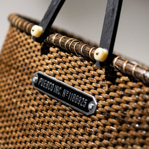 closeup of handwoven rattan harvest basket showing metal plate of puebco branding