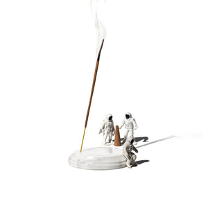 white marble incense holder with little figurine next to it