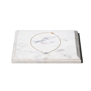 white marble plate with fine necklace on top