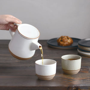 tea poured out of ceramic teapot into a cup