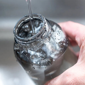 water poured into water bottle in grey by kinto