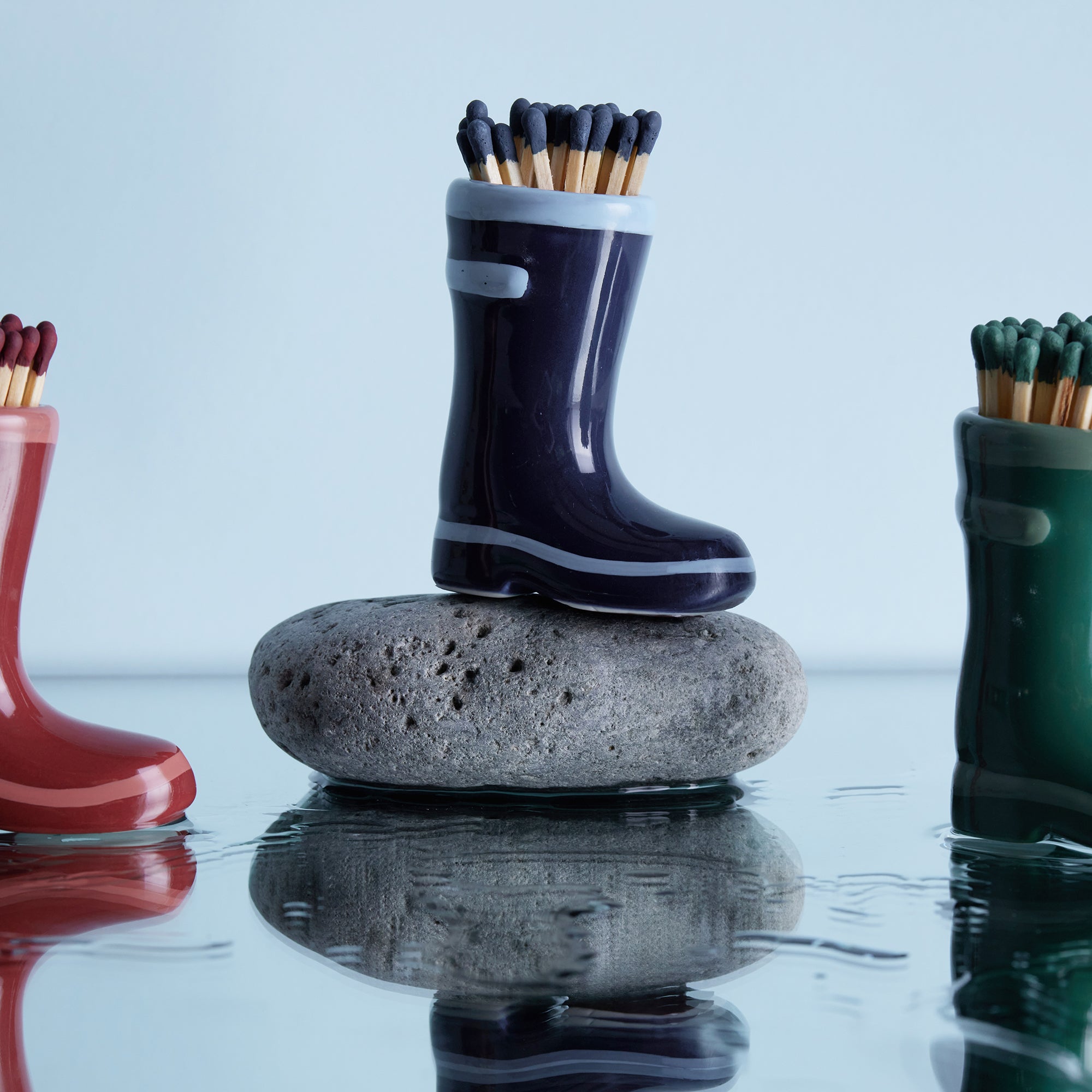 navy blue ceramic wellington boots holding matches